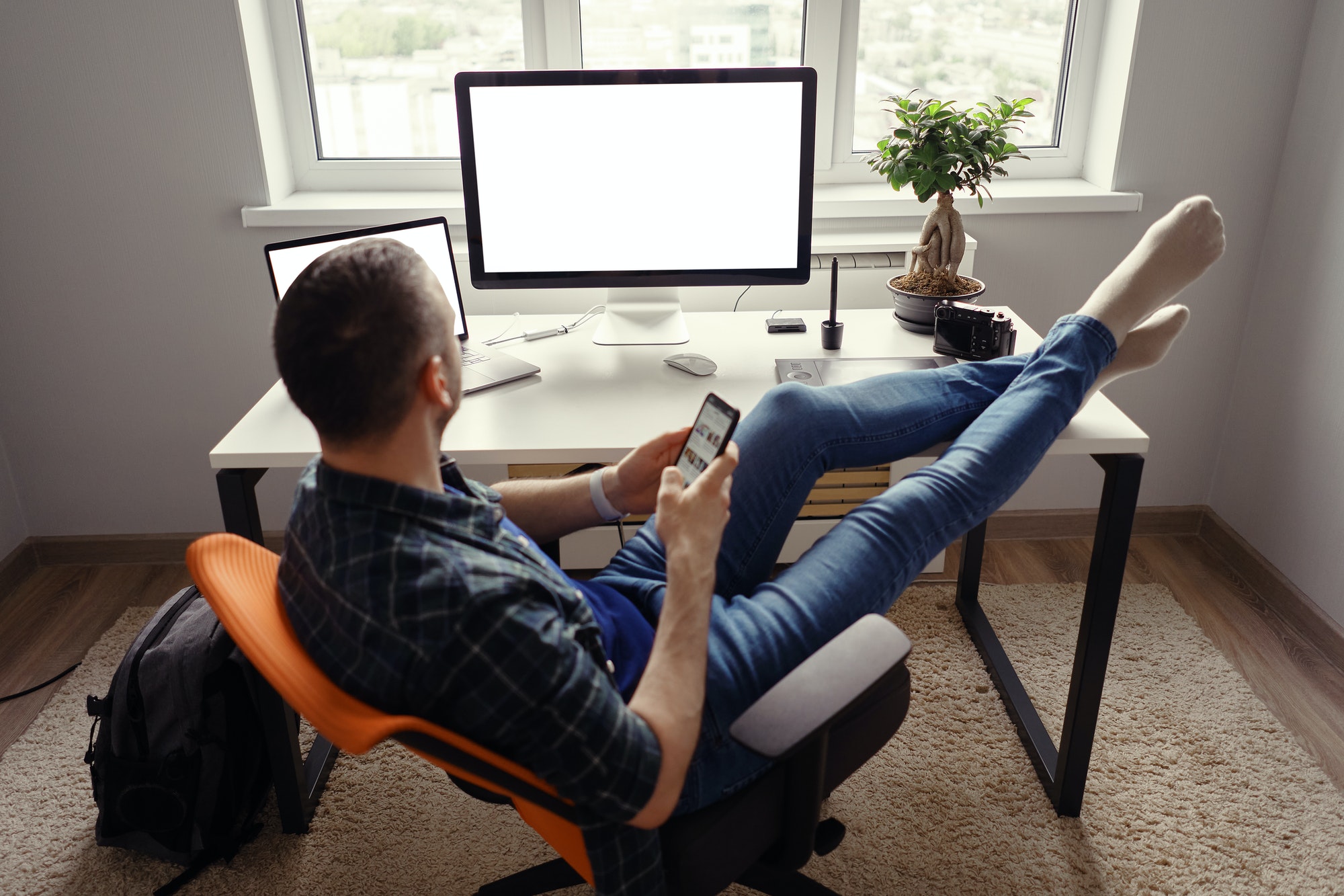 Modern man in home office relaxing with legs on the table